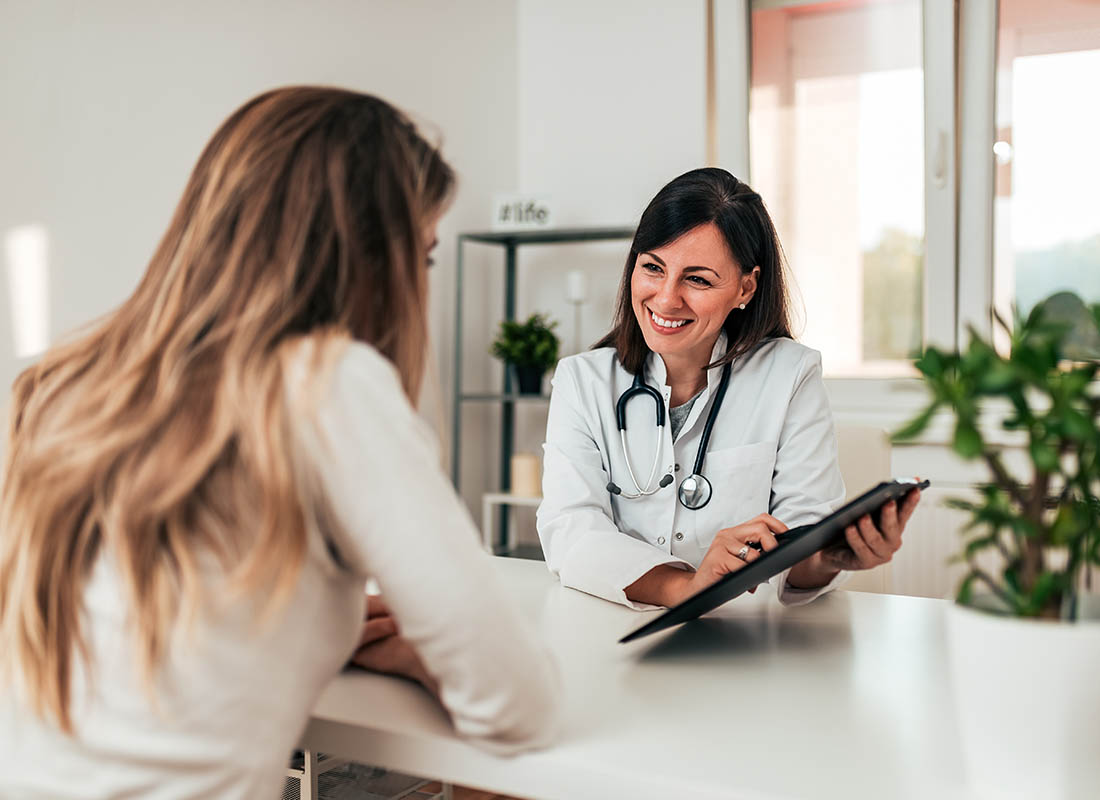 Group Health Insurance - Doctor Consulting Young Patient at the Doctors Office